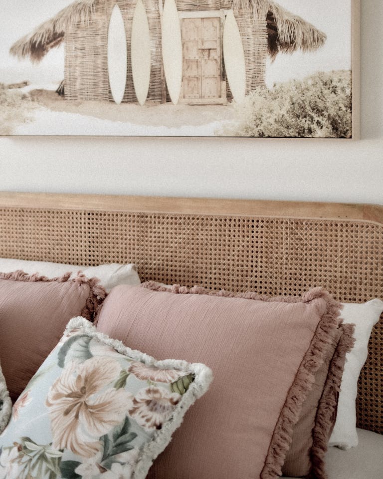 A cozy bedroom corner featuring surfboard art and pastel cushions, perfect for a beach-inspired interior.