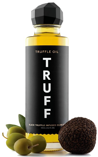 Truff truffle oil in a glass bottle with mushrooms next to it