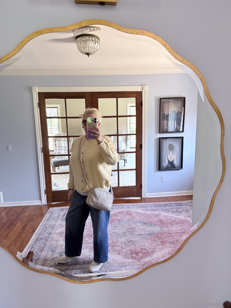 woman standing in mirror showing crossbody bag