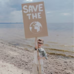 A child holding a sign for saving the earth