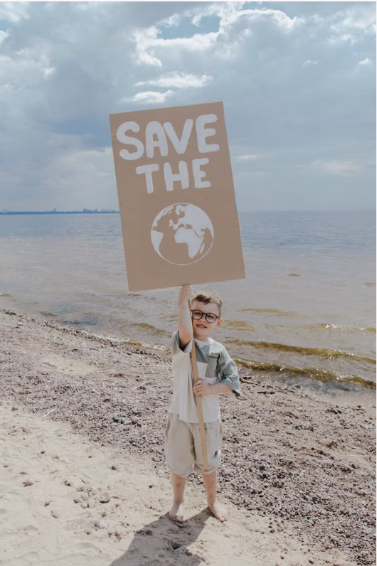 A child holding a sign for saving the earth