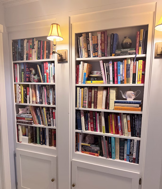 bookcase with collected decor and scones