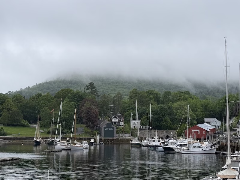 camden maine boats in the harbor with a pretty fog in the mountains