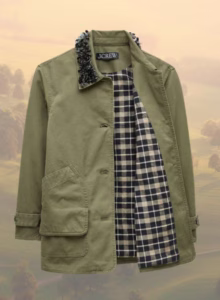 green barn jacket with plaid lining on top of countryside background