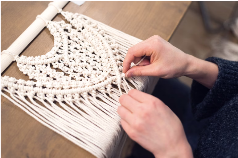woman's hands creating macrame